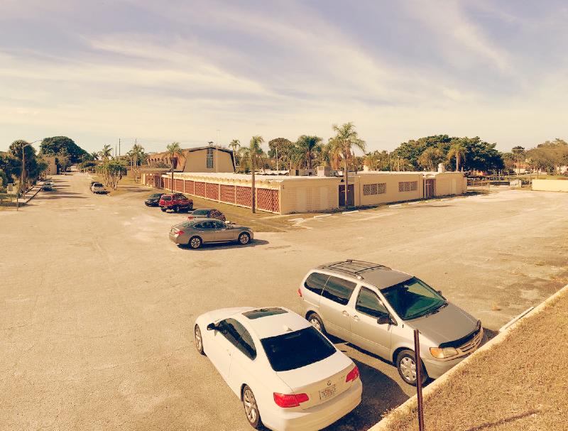 A big parking space with few parked cars